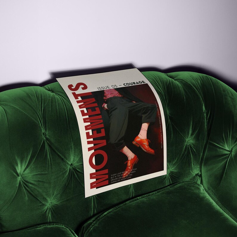 May include: A magazine titled "MOVEMENTS" with the issue number 05, "COURAGE", rests on a dark green velvet tufted sofa. The magazine cover features a person in dark pants and orange shoes.
