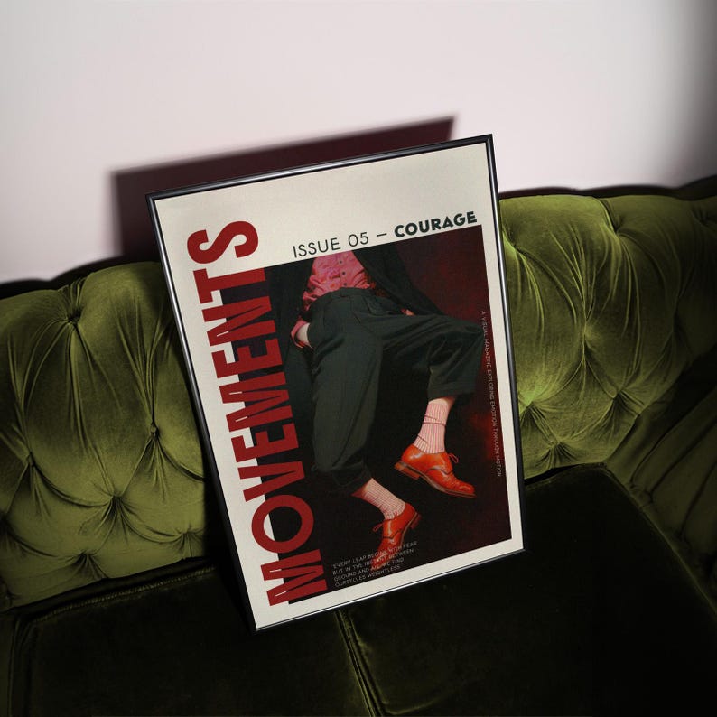 May include: A framed magazine cover titled "MOVEMENTS" with the text "ISSUE 05 - COURAGE." The cover features a person in dark pants and orange shoes. The magazine is resting on a green velvet couch.