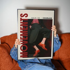 May include: A framed magazine cover with the word "MOVEMENTS" in large red letters. The cover features a person in dark pants, a pink shirt, and orange shoes. The text "ISSUE 05 - COURAGE" is also visible.