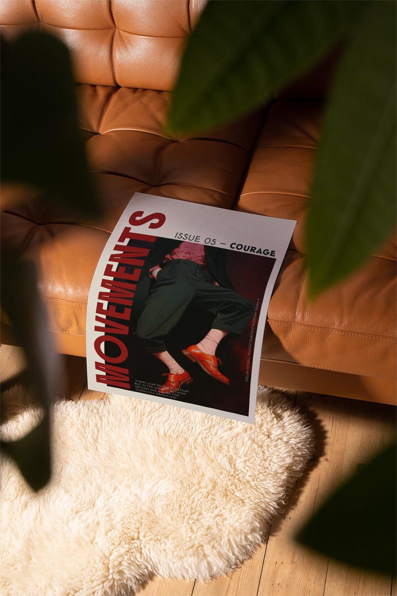 May include: A magazine titled "MOVEMENTS" with the text "ISSUE 05 - COURAGE" is displayed on a brown leather couch. The magazine cover features a person wearing dark green pants and orange shoes. A white fluffy rug is in the foreground.