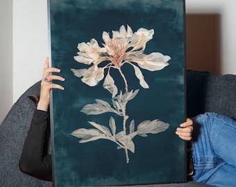 May include: A framed botanical print featuring a detailed illustration of a flower with large, delicate petals and leaves. The artwork is set against a dark teal background, creating a striking contrast. The print is encased in a black frame.
