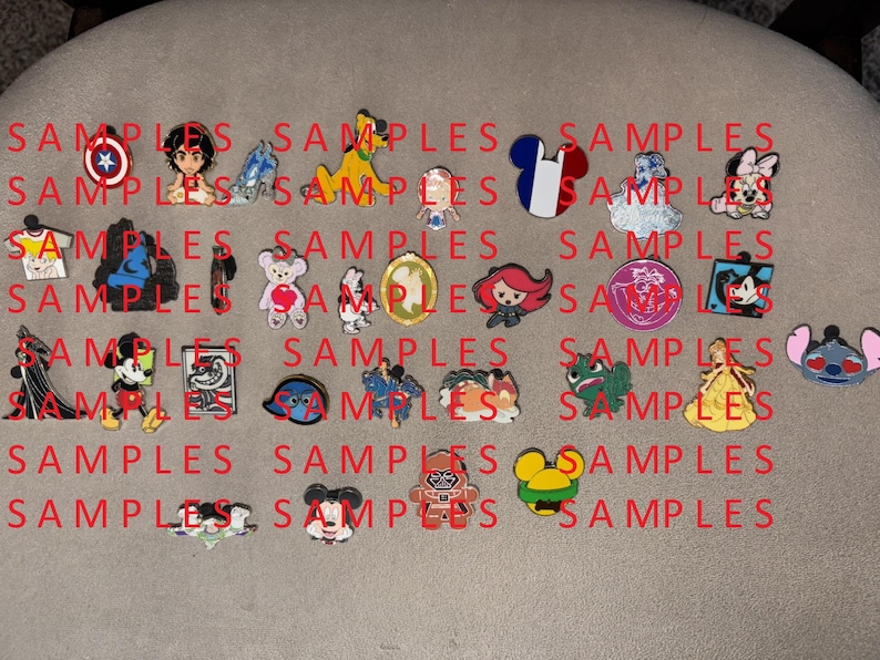 May include: A selection of colourful enamel pins showcasing cartoon characters and symbols. Designs include a shield, a character with a blue outfit, a yellow dog, a French flag, a cloud, a bear with a heart, a bat, Mickey Mouse, and more. The word "SAMPLES" is printed in red.