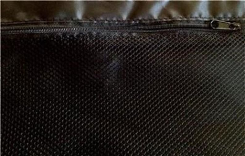 May include: Close-up of a black mesh fabric with a zipper closure. The zipper is dark-colored and runs horizontally across the top of the fabric. The mesh has a diamond pattern.