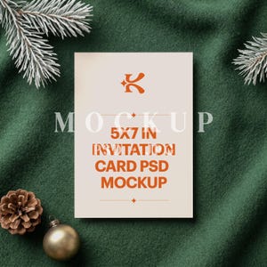 May include: A rectangular 5x7 inch invitation card mockup featuring a cream-colored surface with orange text that reads MOCKUP 5X7 IN INVITATION CARD PSD MOCKUP and a stylized orange logo at the top, centered on a dark green textured fabric background.