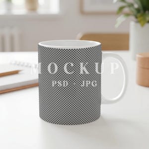 Puede incluir: Una taza de cerámica blanca con un patrón de cuadros negros y blancos repetido en toda su superficie exterior. El centro de la taza muestra el texto blanco MOCKUP PSD + JPG, indicando una plantilla digital para mostrar diseños.