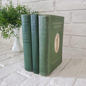 May include: Three vintage green hardcover books standing upright. The first book is titled Willow Tree Nights and Days by Paine. The second is The Song of the Cardinal by Porter. The third is Round the Corner in Gay Street by Grace S. Richmond.
