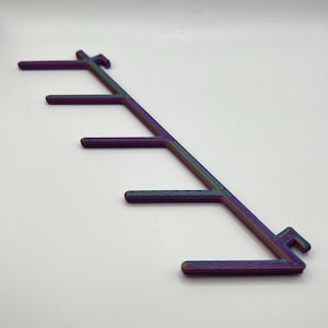May include: A multi-colored plastic hook rack with five hooks. The rack is designed to hang items like keys, towels, or other small objects.