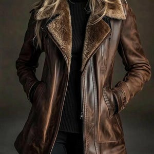 May include: A brown leather jacket with a shearling collar. The jacket has a zipper closure, pockets, and a tailored fit. The model is wearing a black turtleneck and black pants.