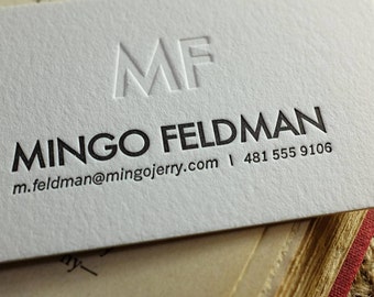 Könnte beinhalten: Eine weiße Visitenkarte mit schwarzem Text. Der Text lautet "Mingo Feldman", "m.feldman@mingojerry.com" und "481 555 9106". Oben auf der Karte sind die Initialen "MF" in einer fetten, geprägten Schrift dargestellt.