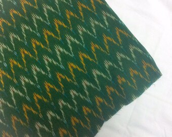 May include: Green fabric with a yellow, white, and blue ikat pattern.