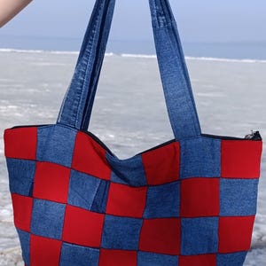 Jeansbeutel mit Reißverschluss in einem rot-blau kariertem Muster. Handgemachte Tasche aus recycelten Jeans.
