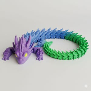 Puede incluir: Un juguete de dragón articulado impreso en 3D en tonos de morado, azul y verde. El dragón tiene un diseño detallado y puntiagudo con ojos amarillos. El cuerpo está segmentado, lo que permite una postura flexible. El dragón está tumbado sobre una superficie blanca.
