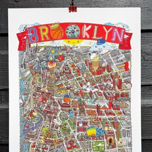 May include: A colorful illustrated map of Brooklyn, New York City. The map features landmarks, buildings, and iconic symbols of the borough, including the Brooklyn Bridge, Coney Island, and the Brooklyn Nets basketball team. The map is surrounded by a red banner with the word "BROOKLYN" in white letters.