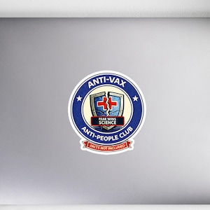 May include: A sticker with a circular design featuring the text "ANTI-VAX" and "ANTI-PEOPLE CLUB". The design includes a shield with a medical cross and the words "FEAR WINS SCIENCE". The sticker has a white border and a red banner that says "FACTS NOT INCLUDED".