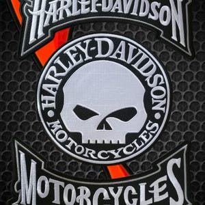 Puede incluir: Parche bordado de Harley-Davidson con el logotipo de la marca y un diseño de calavera. El parche incluye las palabras "Harley-Davidson" y "Motorcycles" en costuras blancas sobre un fondo negro, con un acento naranja.