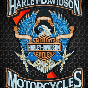 Puede incluir: Un conjunto de parches bordados de Harley-Davidson con un emblema central de águila con alas azules, rayos y el texto Harley-Davidson Motor Cycles Since 1903. Incluye parches curvos superior e inferior con el texto Harley-Davidson Motorcycles.