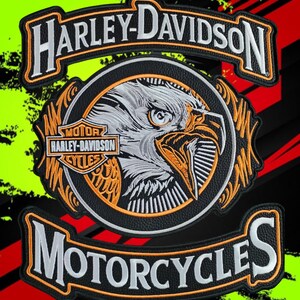 Puede incluir: Un conjunto de tres parches bordados que presentan el texto Harley-Davidson en blanco sobre un fondo negro con bordes naranjas. El parche central circular muestra un perfil detallado de una cabeza de águila y el logo Harley-Davidson Motor Cycles.