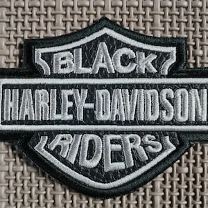 Black Rider biker patches in gray and black, for sewing onto a motorcycle jacket.
