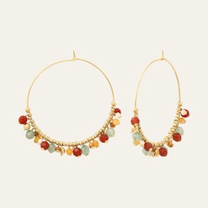 May include: A pair of gold-coloured hoop earrings. Each earring has a curved row of small gold beads and is decorated with hanging beads in red, green, and yellow. The earrings are set against a plain, neutral background.