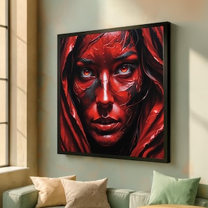 May include: A framed artwork featuring a striking portrait of a person with red skin and intense red eyes. The person is framed by a red hood, creating a dramatic and captivating image. The artwork is displayed on a light green wall.