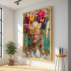 May include: A large framed artwork depicting a woman with a butterfly mask and floral headdress. The artwork has a gold frame and a textured background with gold, green, and teal tones. The woman wears ornate gold jewellery with red accents.