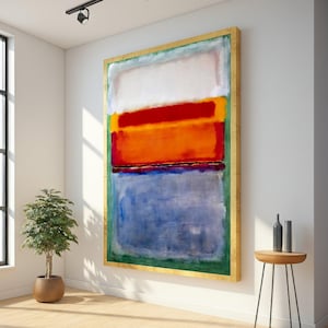 Puede incluir: Pintura abstracta con marco dorado. La obra presenta bloques rectangulares de color: blanco, rojo, naranja y azul. La pintura se exhibe en una pared blanca en una habitación bien iluminada con un pequeño árbol en maceta y una mesa auxiliar.