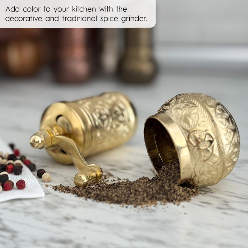 May include: A gold-colored spice grinder with intricate embossed patterns, with ground spices spilling out. The text in the image reads: "Add color to your kitchen with the decorative and traditional spice grinder."
