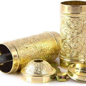 Pode incluir: Um conjunto de componentes de moedor de especiarias de metal dourado ornamentado. As pe&ccedil;as incluem um corpo cil&iacute;ndrico, uma base, uma tampa e uma al&ccedil;a. As superf&iacute;cies s&atilde;o decoradas com um padr&atilde;o floral em relevo. O moedor foi projetado para ser montado.