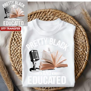 May include: White t-shirt with the words "PRETTY BLACK AND EDUCATED" in a bold, stylized font. The design includes a vintage microphone and an open book. The shirt is displayed on a woven basket.