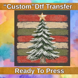 May include: A Custom Dtf Transfer Ready To Press graphic featuring a central green Christmas tree with white snow-dusted branches, topped with a gold star. The tree is set against a background of horizontal distressed red, green, and tan stripes.