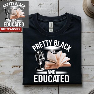 May include: Black t-shirt with the words "PRETTY BLACK AND EDUCATED" in white, along with a microphone and an open book graphic. The shirt is made of a soft material and is perfect for anyone who loves reading and podcasting.