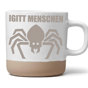 Könnte beinhalten: Ein weißer Keramikbecher mit gesprenkelter Oberfläche und einem beigefarbenen Boden. Auf der Vorderseite befindet sich eine stilisierte hellbraune Spinne unter dem Schriftzug IGITT MENSCHEN, der in einer fetten, serifenlosen Schrift oben steht.