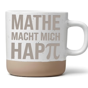 Könnte beinhalten: Ein weißer Keramikbecher mit gesprenkelter Oberfläche und einem beigen Boden. Auf der Vorderseite steht der Text MATHE MACHT MICH HAPπ in großen, hellbraunen Buchstaben, wobei der griechische Buchstabe Pi das P im Wort HAPPY ersetzt.