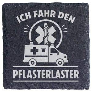Könnte beinhalten: Ein quadratischer Untersetzer aus schwarzem Schiefer mit einer weißen Gravur eines Krankenwagens und dem Stern des Lebens. Der Text ICH FAHR DEN PFLASTERLASTER ist in weißen Großbuchstaben über und unter dem Motiv abgebildet.