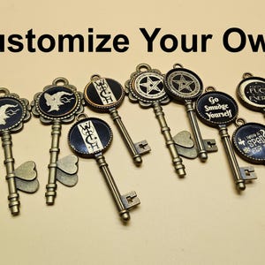 May include: Antique bronze-colored decorative keys with various designs, including a witch silhouette, a star, and phrases like "Go Smudge Yourself." The text "Customize Your Own!" is displayed above the keys.