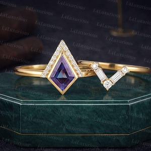 Peut inclure: Un ensemble de bagues en or avec un design géométrique. La bague de fiançailles présente une pierre centrale en forme de cerf-volant avec un halo de petits diamants. Une alliance assortie avec des diamants baguette et ronds complète l'ensemble.