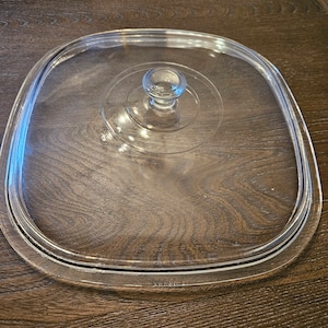 Puede incluir: Tapa de vidrio transparente para una olla de cocción lenta con una perilla redonda en la parte superior.