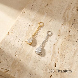 Colgante de cadena con colgante de gota de agua de titanio y circonitas cúbicas, pendiente tipo clicker para piercing en el lóbulo superior.