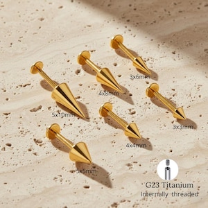 Puede incluir: Joyas para el cuerpo de titanio G23 doradas, con rosca interna. La imagen muestra seis piezas con extremos en forma de cono de varios tamaños, incluyendo 5x10mm, 4x8mm, 5x5mm, 4x4mm, 3x6mm y 3x3mm. Las joyas tienen un disco plano en un extremo.
