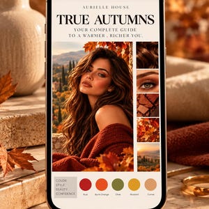 Op de afbeelding: Een smartphonescherm met een digitale gids getiteld AURIELLE HOUSE TRUE AUTUMNS YOUR COMPLETE GUIDE TO A WARMER, RICHER YOU. Het scherm toont een portret van een persoon met golvend bruin haar, een kleurenpalet met de labels Rust, Burnt Orange, Olive, Mustard, Camel, en kleinere ingevoegde afbeeldingen van haar, een oog, make-up, herfstbladeren en een landschap.
