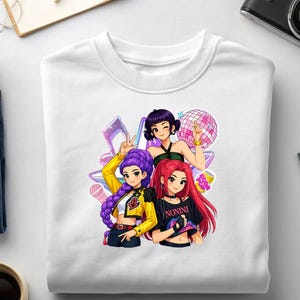 May include: White crew neck sweatshirt with a vibrant graphic of three anime-style women. The women have different hair colours and are posed with musical elements. One shirt has the word "NONINI" printed on it.