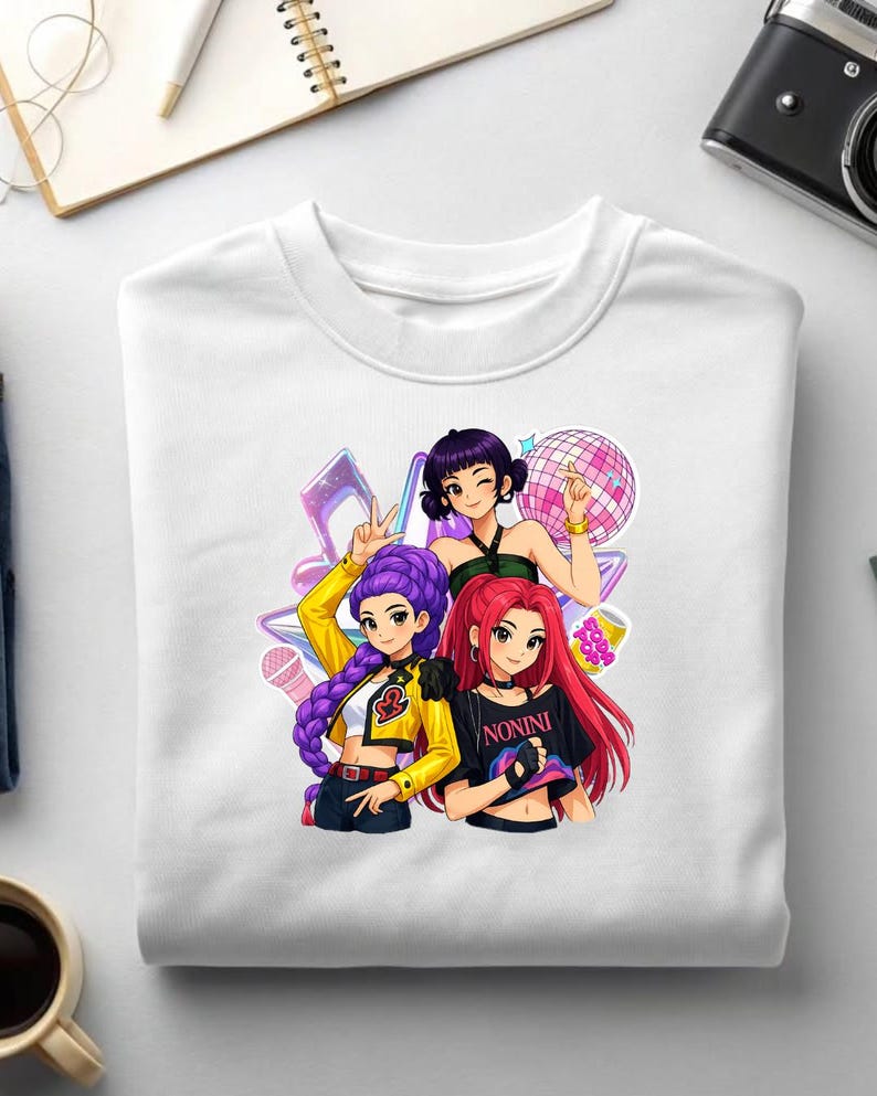 May include: White crew neck sweatshirt with a vibrant graphic of three anime-style women. The women have different hair colours and are posed with musical elements. One shirt has the word "NONINI" printed on it.
