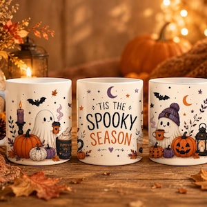 Könnte beinhalten: Drei weiße Keramiktassen mit Halloween-Illustrationen. Die Motive zeigen Geister, Kürbisse, Fledermäuse und Herbstblätter. Die mittlere Tasse trägt den Schriftzug 'TIS THE SPOOKY SEASON' in schwarzer und orangefarbener Schrift mit einem Mond.