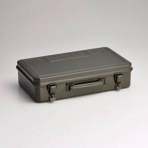 Op de afbeelding: Olijfgroene metalen gereedschapskist met een handvat en twee grendels. Het woord "TOOLBOX" is in het deksel geëmbosseerd. De rechthoekige doos heeft een handvat om te dragen. De gereedschapskist wordt waarschijnlijk gebruikt voor het opbergen van gereedschap.