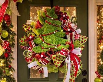 Guirnalda navideña verde peluda y caprichosa con lazo de lunares rojos para decorar la puerta.