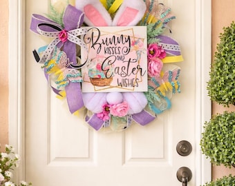 Corona de Pascua en tonos pastel con orejas de conejo: decoración floral primaveral para la puerta