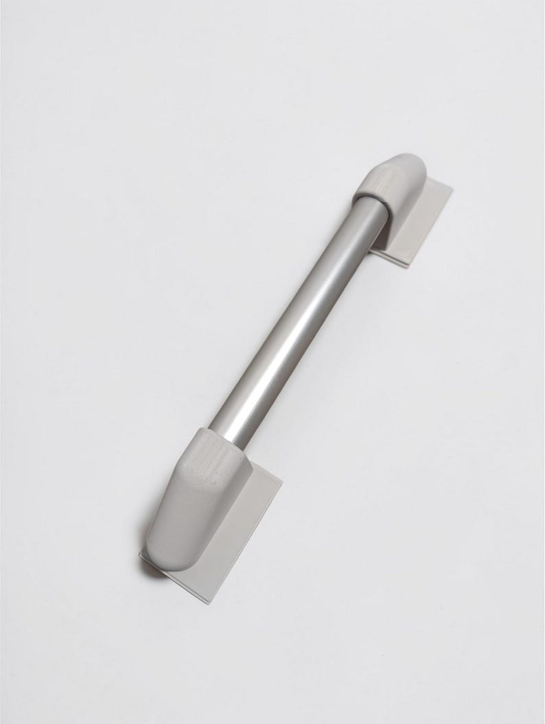 May include: A silver-colored cabinet handle with gray end caps and mounting plates. The handle is a straight bar design, suitable for drawers or cabinet doors. The hardware is shown against a white background.