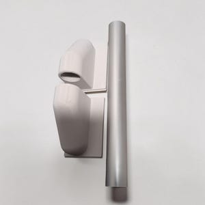 May include: A set of three-dimensional, light gray architectural components. Two angled, box-like forms are mounted on square bases. A cylindrical, vertical piece is positioned next to them. The objects are against a white background.