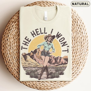 May include: A white ceramic mug with a black handle and the text "But First, Coffee" in a black, handwritten-style font. The mug is on a white surface.