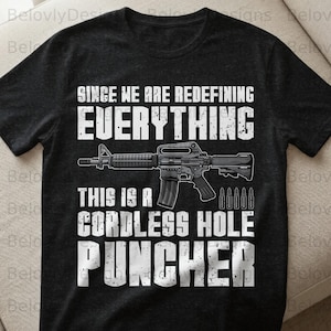 Könnte beinhalten: Schwarzes T-Shirt mit weißem Text und einer Gewehrgrafik. Der Text lautet: „SINCE WE ARE REDEFINING EVERYTHING, THIS IS A CORDLESS HOLE PUNCHER.“
